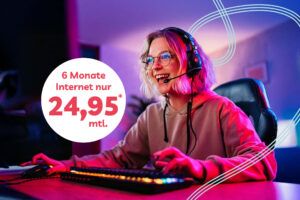 Fröhliche junge Frau mit Headset zockt am Gamer-PC